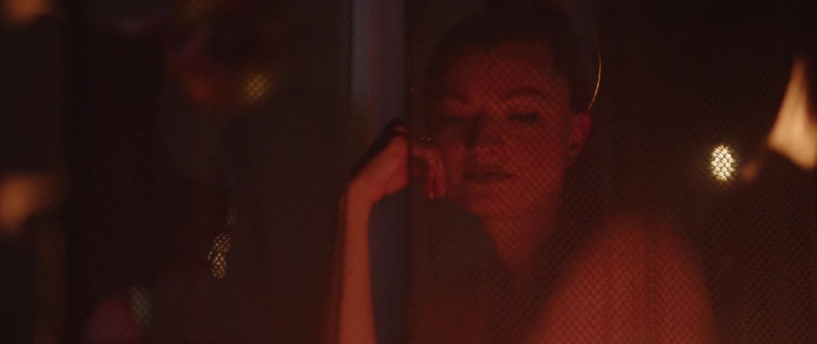 A woman sitting next to a burning fire in the dark