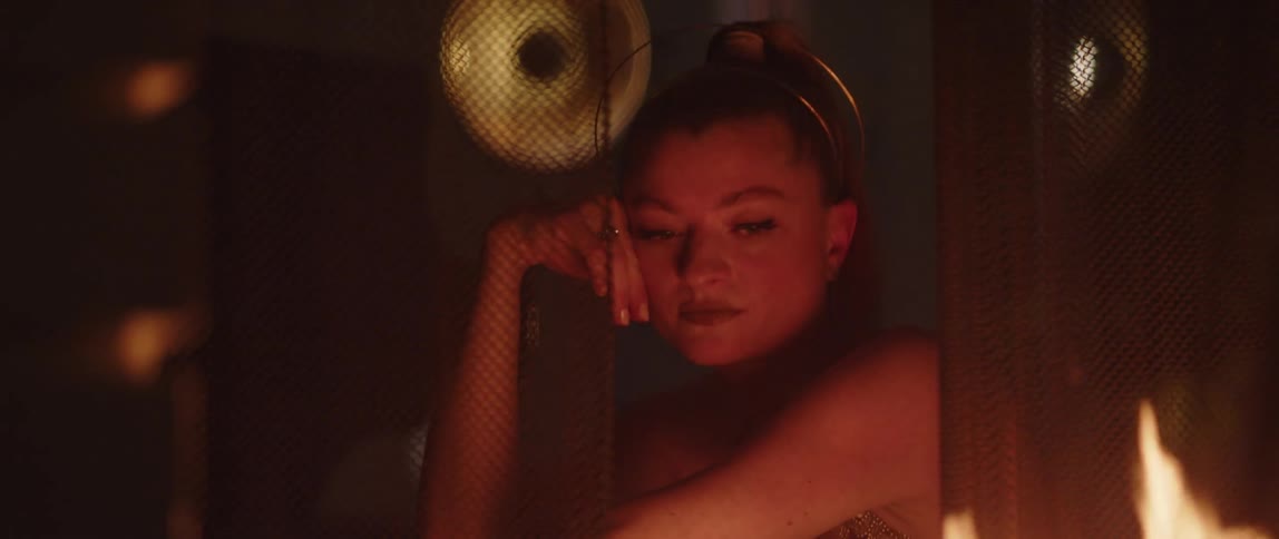 A woman is sitting by the fireplace during the night time