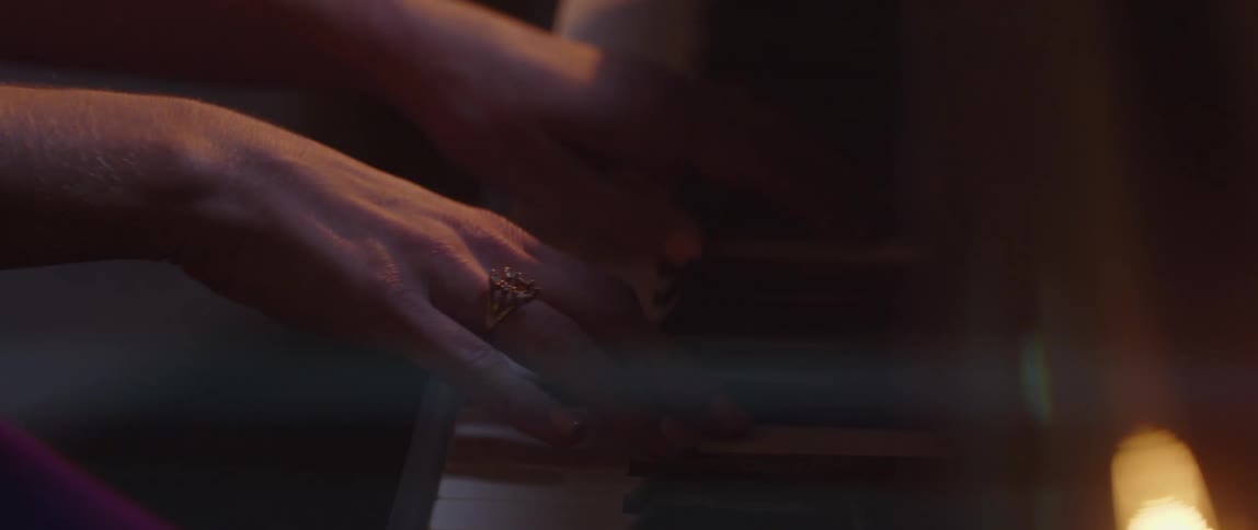 A woman is playing the piano indoors at night