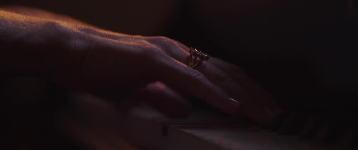 Close up of womans hands with ring playing grand piano