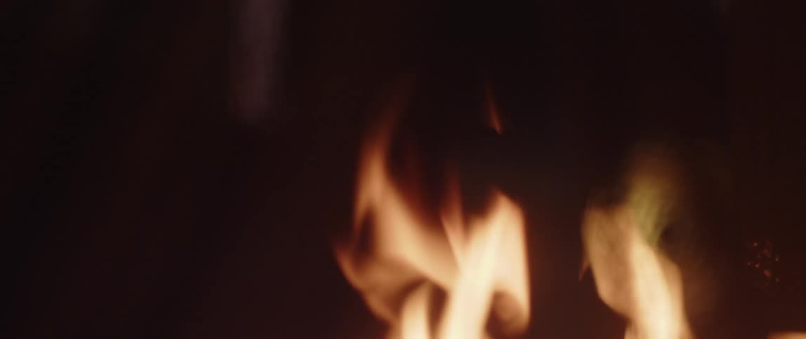 Close up view of the flames of a fire waving and moving in the darkness
