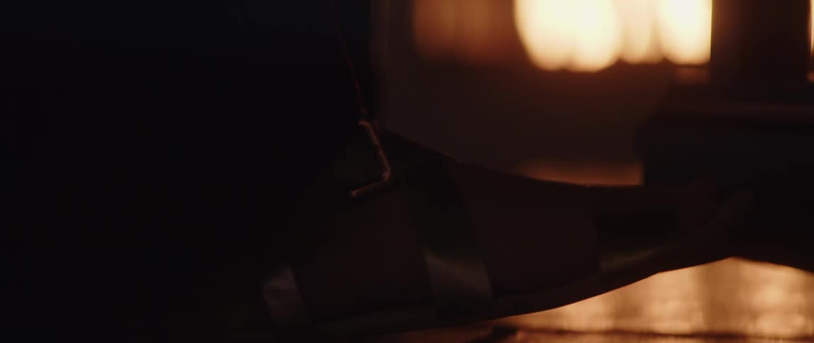 Persons leather shoe next to the fireplace