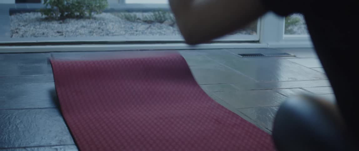 A woman rolls out a yoga mat