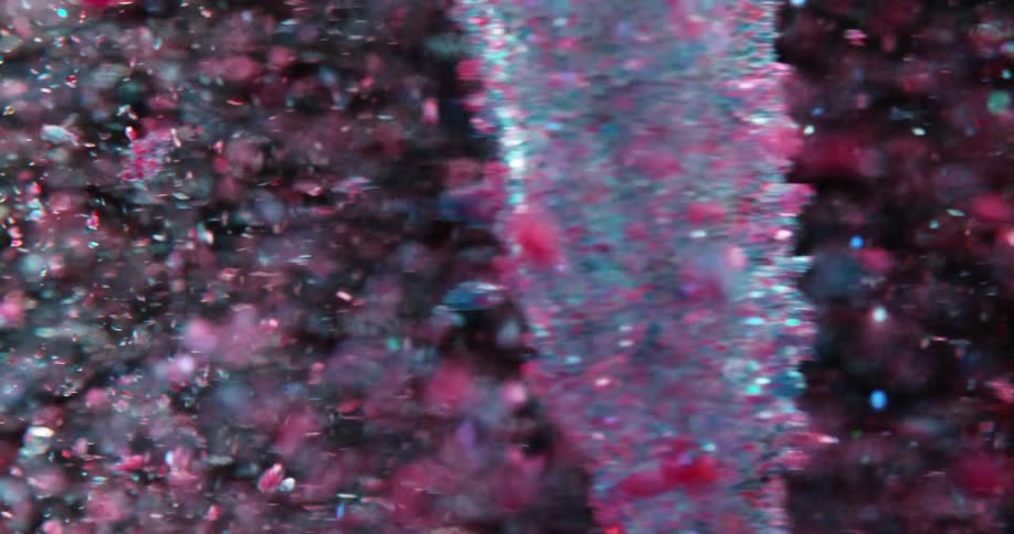 Light blue and pink objects move around a swirling mass as it rotates