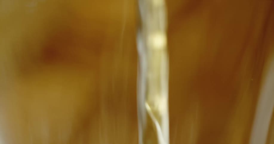 An up close of clear liquid being poured