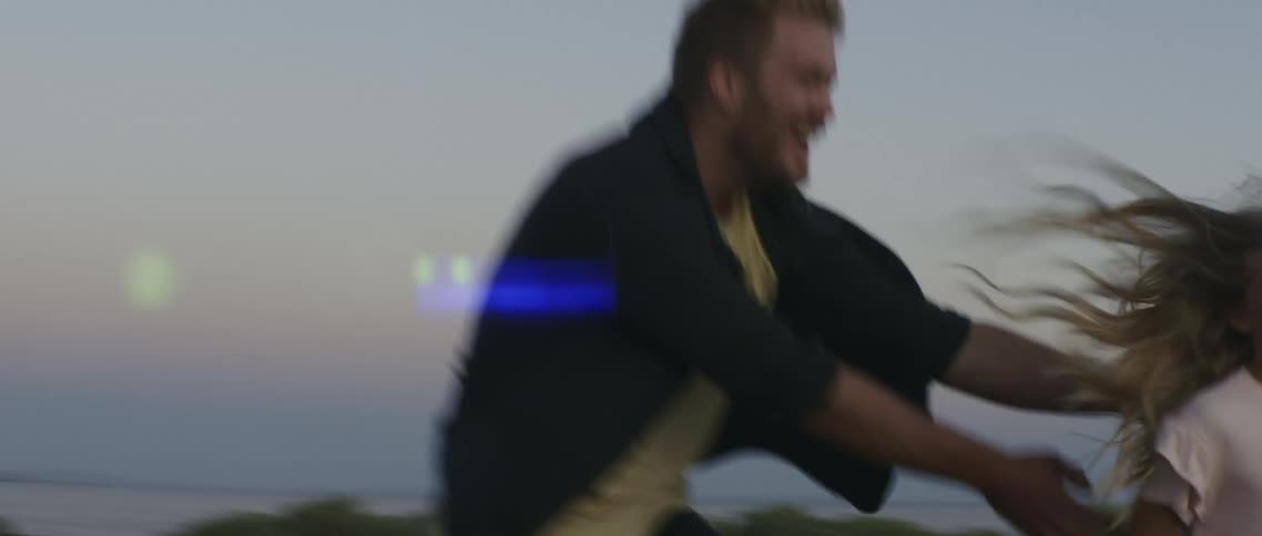 A trucks headlights shining while a man chases after a little girl running
