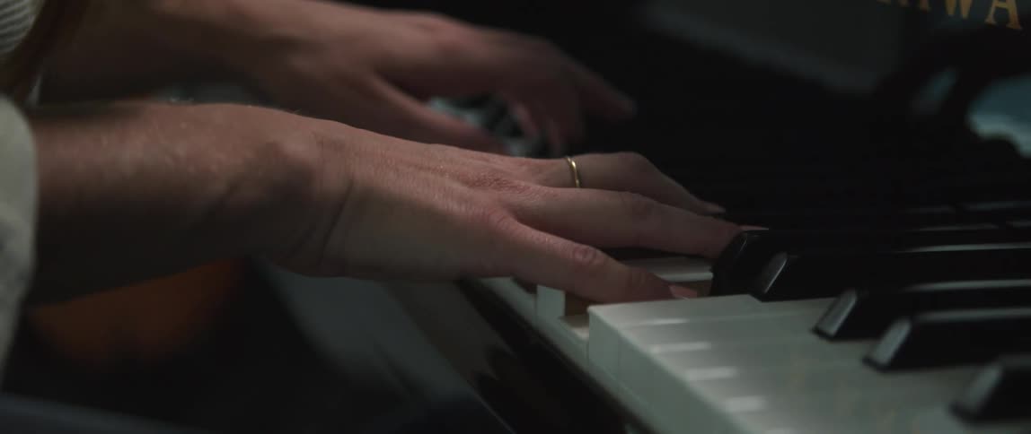 A person wearing a ring playing a piano