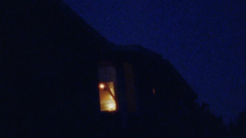 Exterior of building with open door and illuminated room