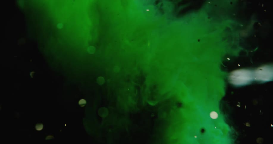 Green smoke twirling around with glitter or water droplets swirling around