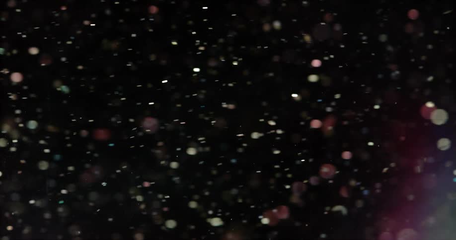 Reflective metallic disks flow against a black background