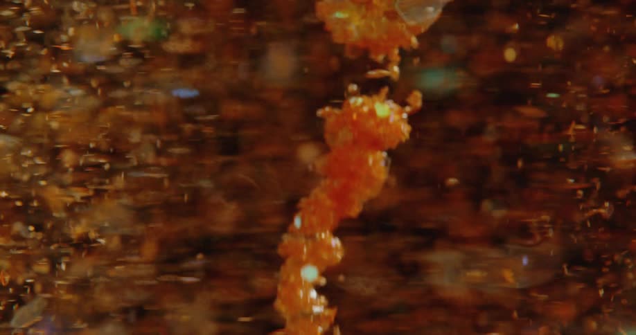 Close up of bubbles spinning and swirling inside a beverage being stirred