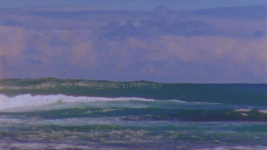 There are men that are surfing in the ocean around the summer time