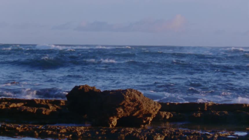 Time lapse view of ocean waves is displayed at dusk