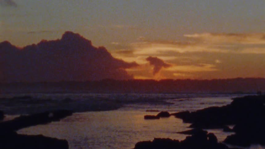 Afterglow of the sun setting behind clouds on the horizon over the coast