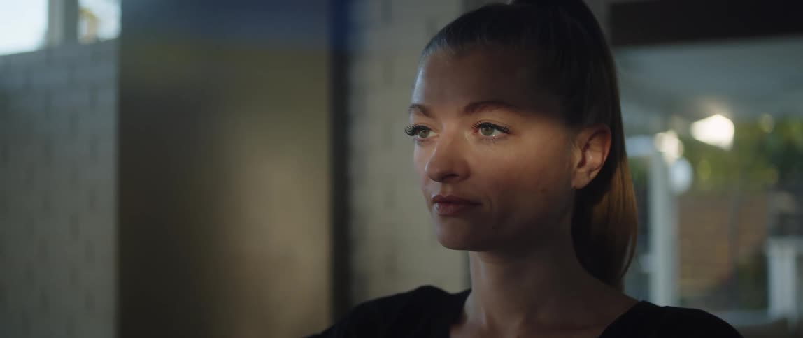 A woman is standing in a room with her eyes closed and then she opens them and blinks