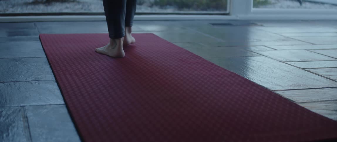 A person walks on the yoga mat for a workout