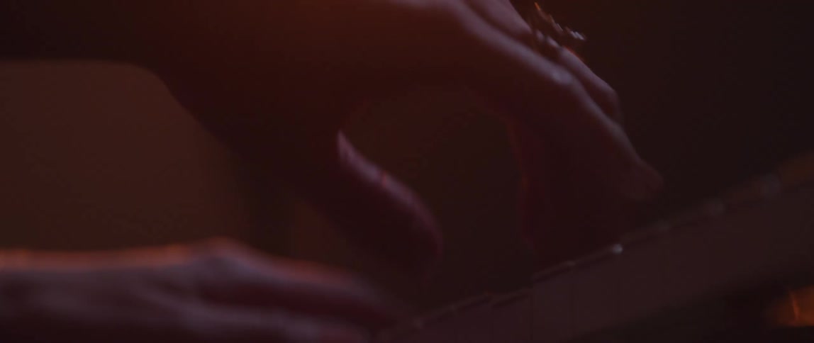 Close up of the slender fingers of a woman playing the piano