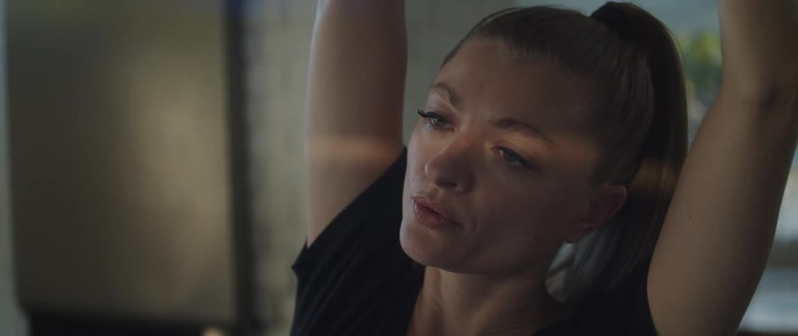 A woman exhaling and closing her eyes while doing a yoga pose