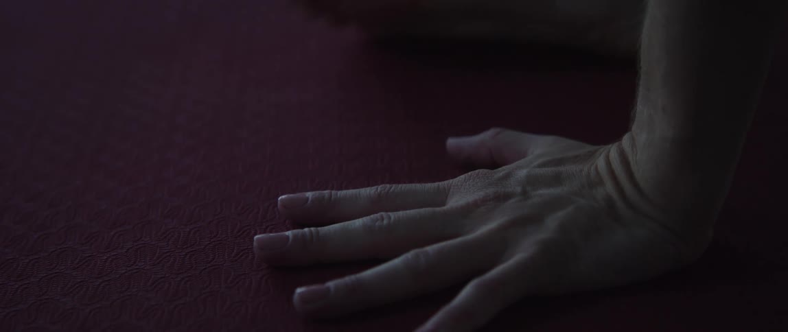 A person with blonde hairs toes and hand on the floor