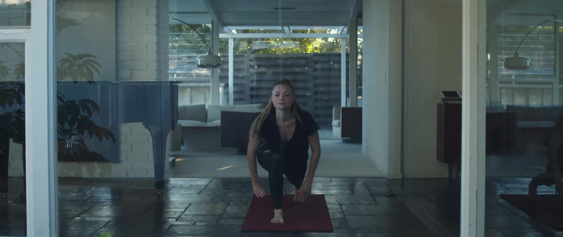 A woman with a long ponytail doing yoga poses on a yoga mat at home