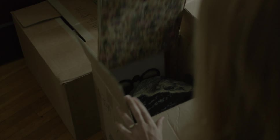A woman pulls an album from a box