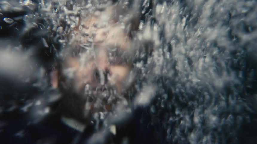 Red haired man in a business suit drowning underwater