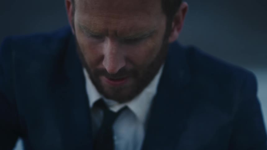 A man sprinting outside in a dirty suit