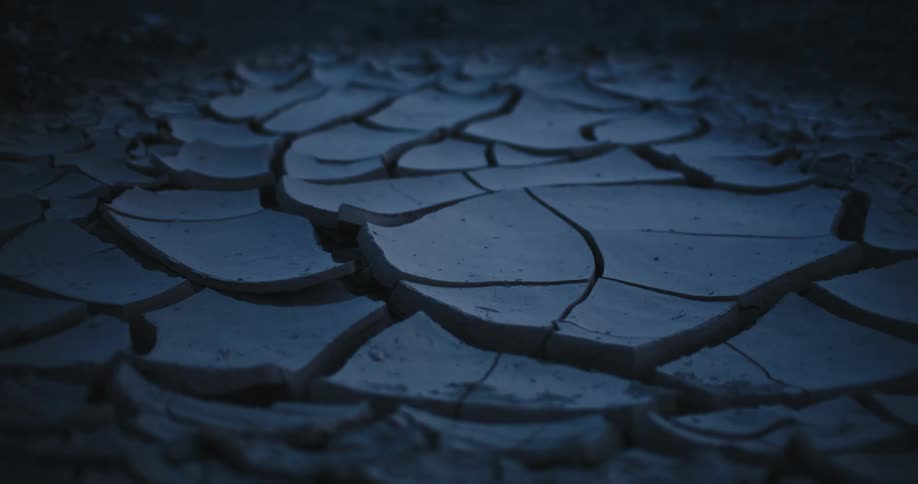 Close up of the broken surface of dry mud in the desert at night