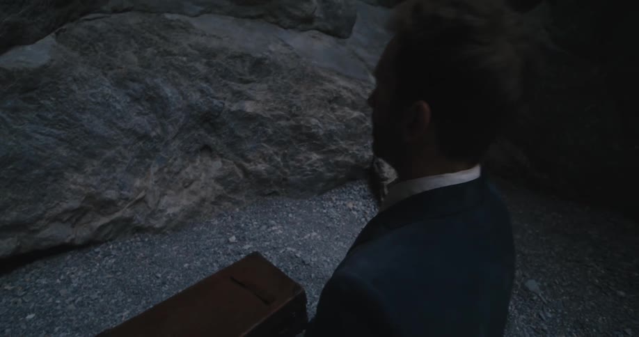 There is a business man with a briefcase that is inside of a cave
