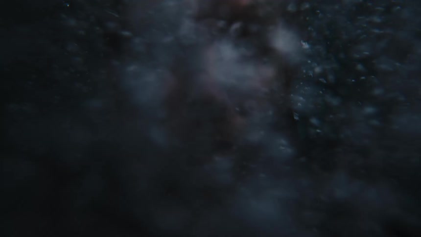 A persons face rises up through the bubbles