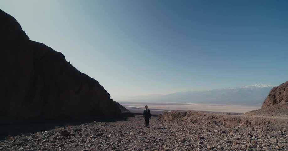 There is a person that is walking down the beach in the day time