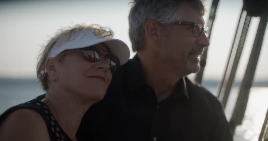 A woman is leaning against a man smiling on a windy day