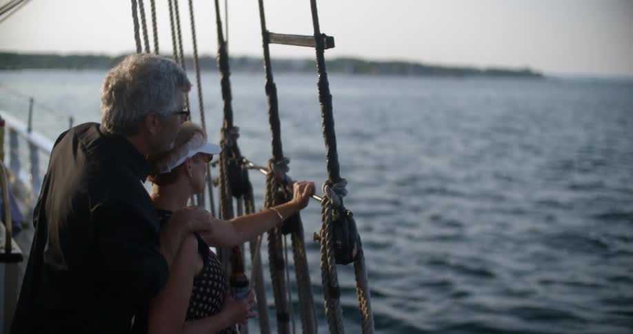 A man and woman talk as they sail on a boat