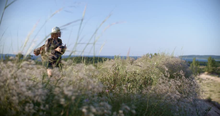 A woman stands in a field on a sunny day