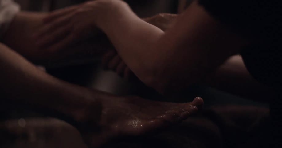 A woman giving a man a pedicure