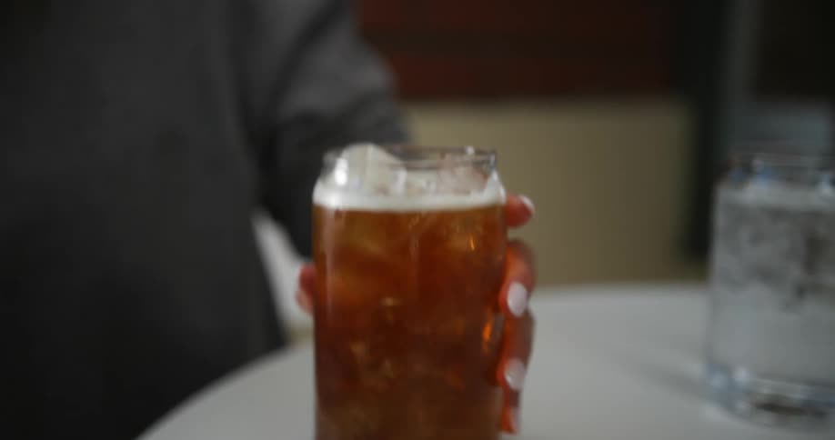 A person is sitting down at a restaurant and drinking some beer
