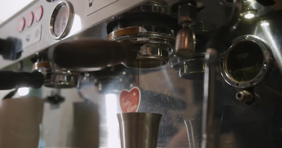Coffee machines making coffee and dripping into cups