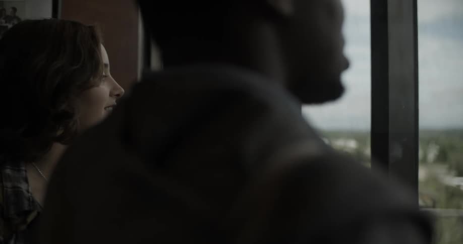 A man and a woman riding in an elevator