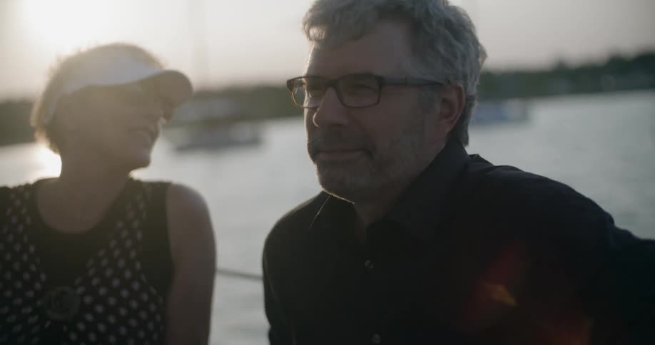 A man and woman ride on a boat at sunset