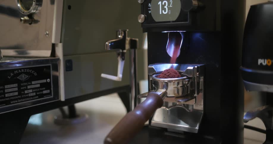 A barista measuring out coffee grounds on a scale