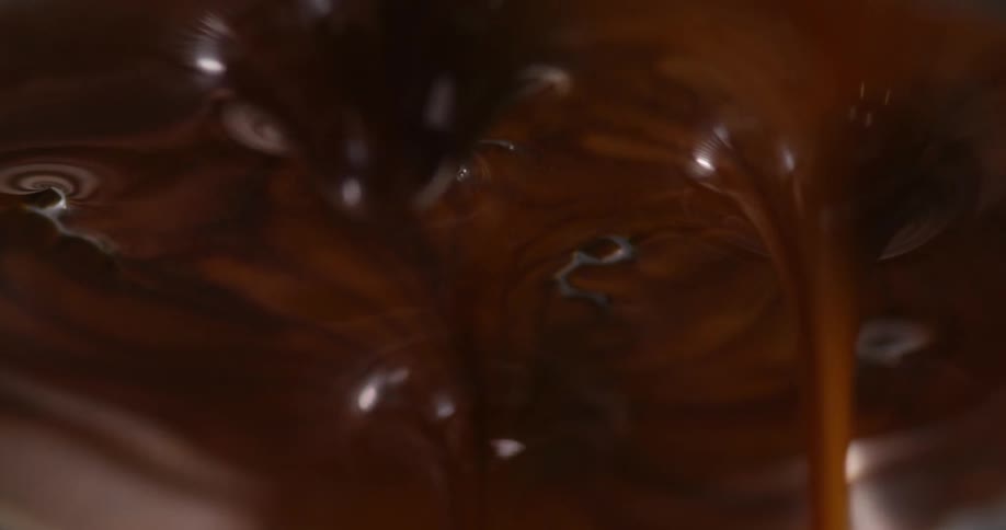 Chocolate being poured over metal in a factory