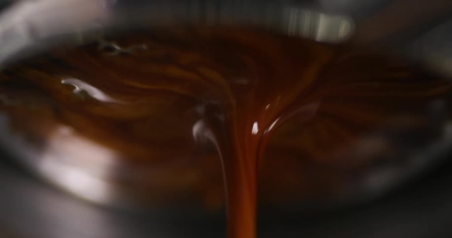 Close up of a stream of hot espresso coffee brewing