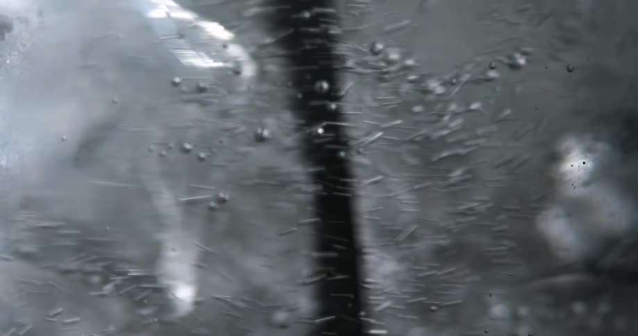 A straw stirring a glass of ice water