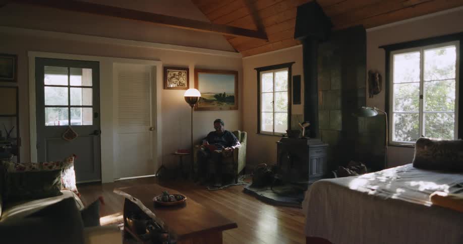 A man is sitting at home reading