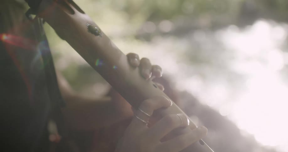 A female outdoors playing a musical instrument
