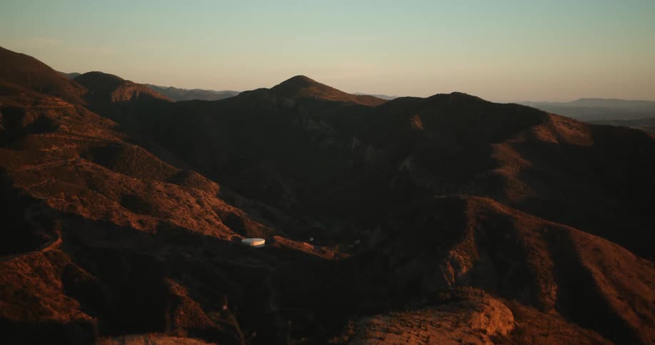 Gentle sunlight bathing the slopes of a mountain range at evening