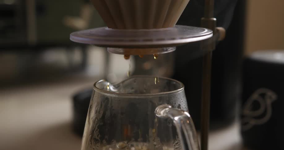 Close up of coffee brewing through a filter into a glass cup