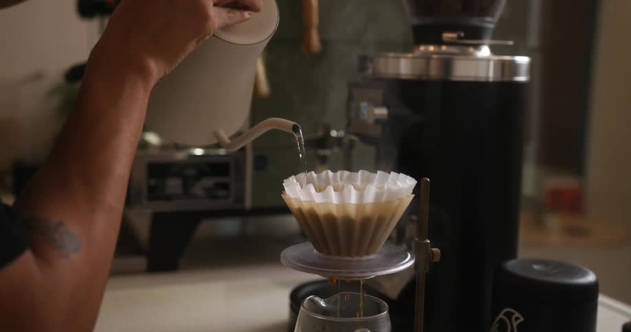 A person is pouring coffee into a pot