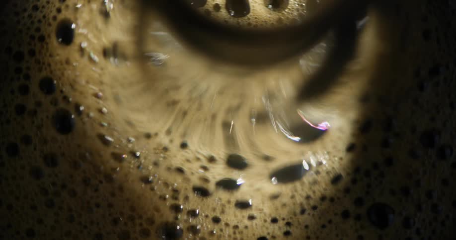 Foam floating on the surface of a stirred pot of coffee