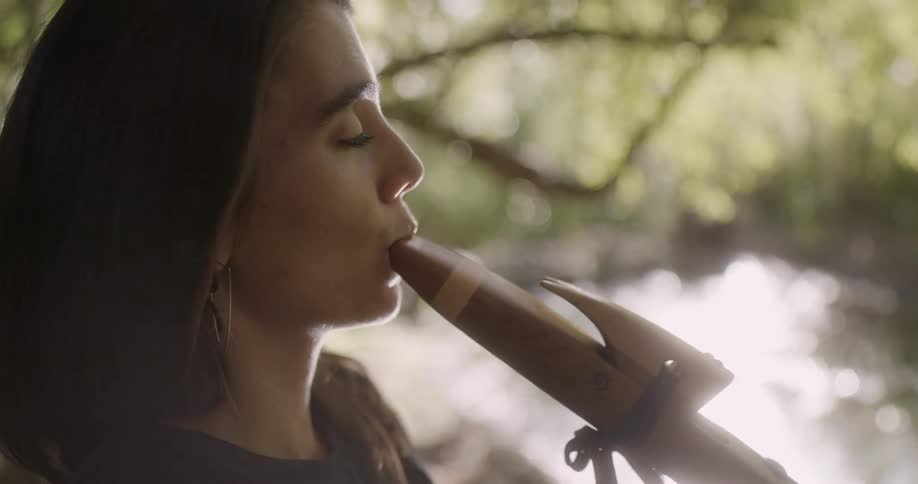 A young white woman is outdoors in the nature area around day time